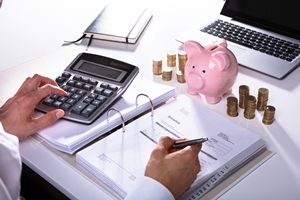 Photo Of Businessman's Hand Calculating Invoice With Calculator