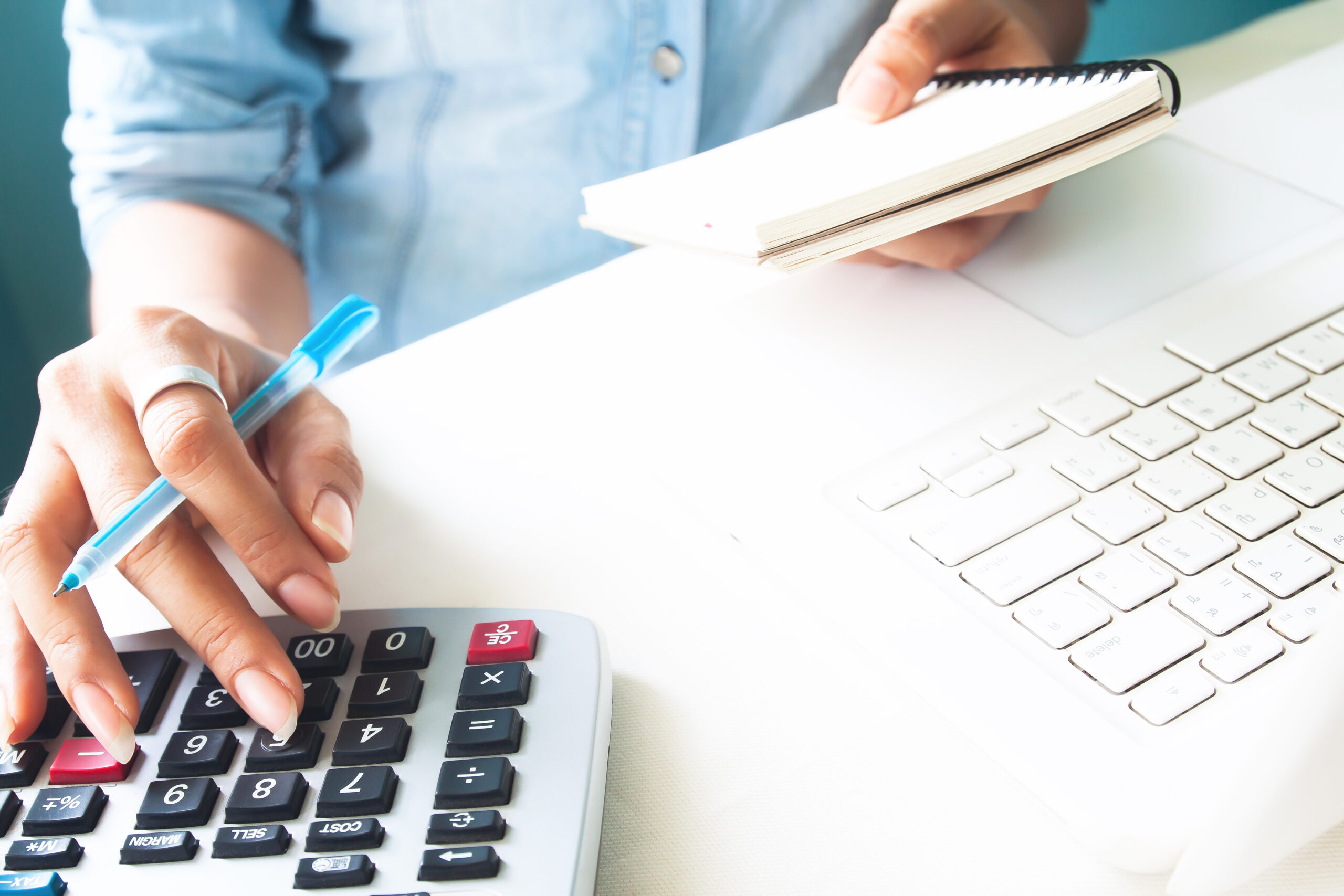 Close up woman's hand using calculator, Work space desk with lap