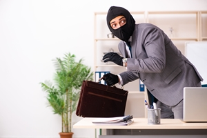 Male gangster stealing information from the office